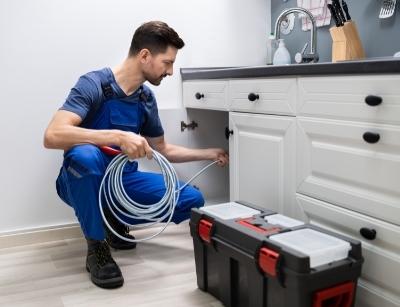 man fixing kitchen sink drain